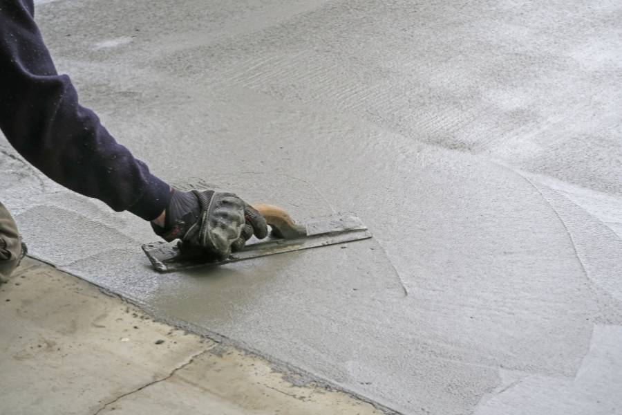 Application de béton désactivé sur une allée extérieure par un professionnel