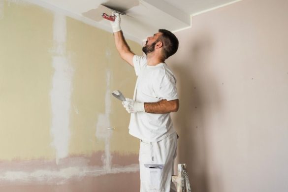 Artisan appliquant de l’enduit au plafond avant de peindre un plafond