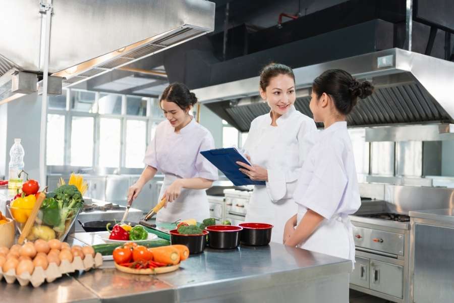 Chefs professionnels préparant des plats dans une cuisine moderne représentant l'art culinaire français